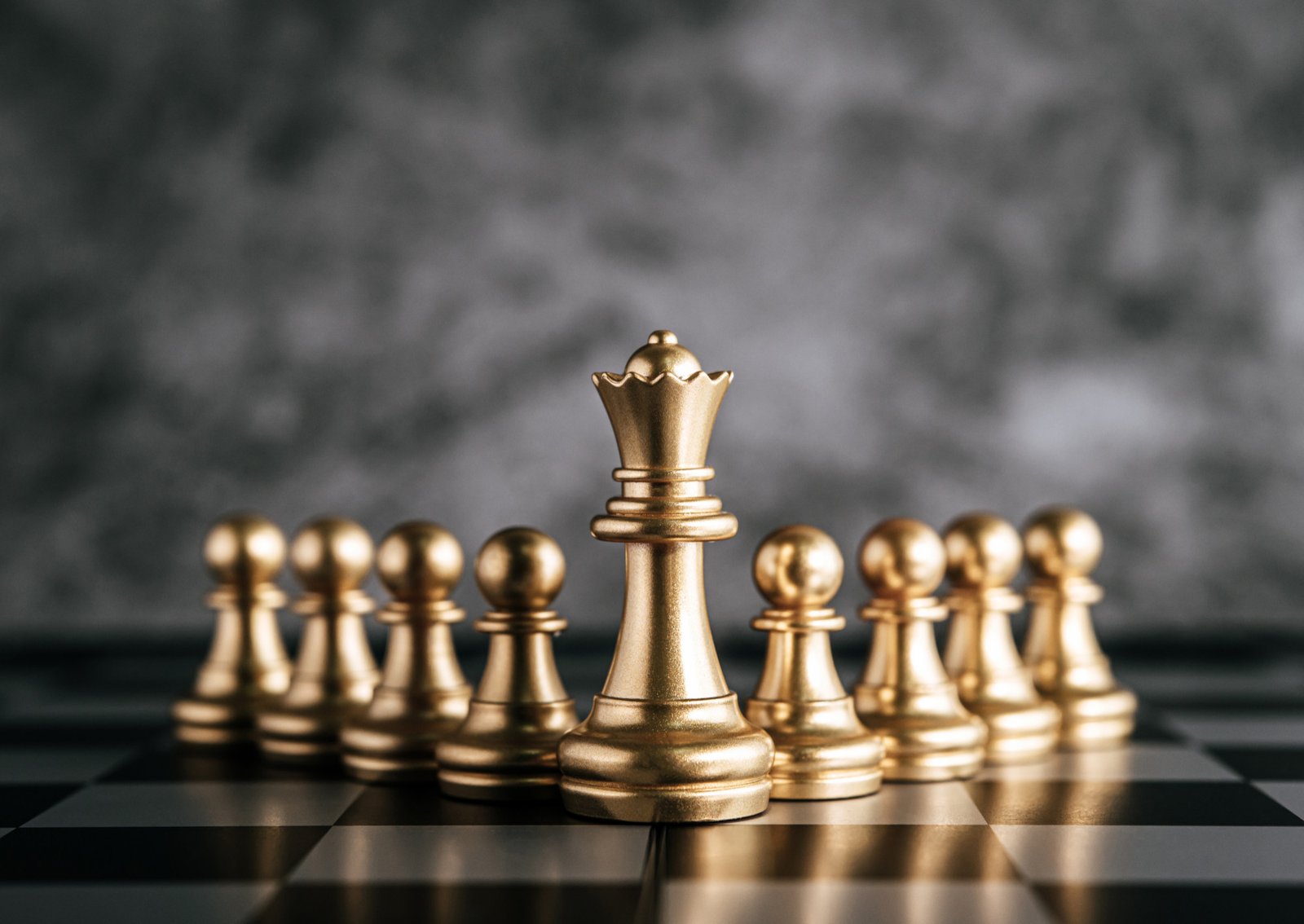 Rainha dourada de xadrez à frente de outras peças, simbolizando liderança estratégica, planejamento e tomada de decisão em consultoria de tecnologia.